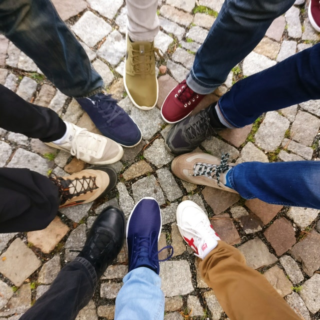 Group of people placing one foot in a circle to show unity 