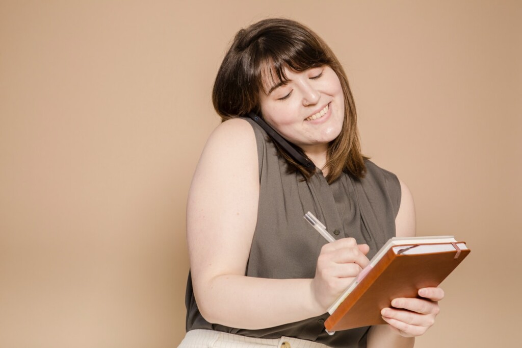 Woman making a phone call and taking notes for couples therapy