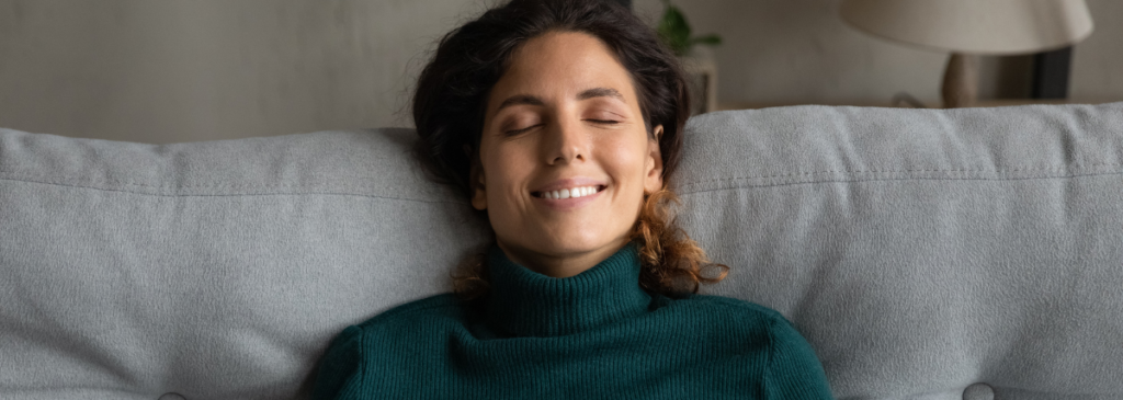 Woman sitting on couch relaxing and meditating