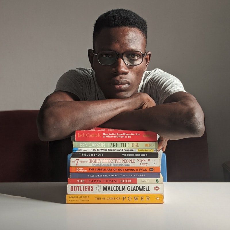 Man leaning on a stack of books