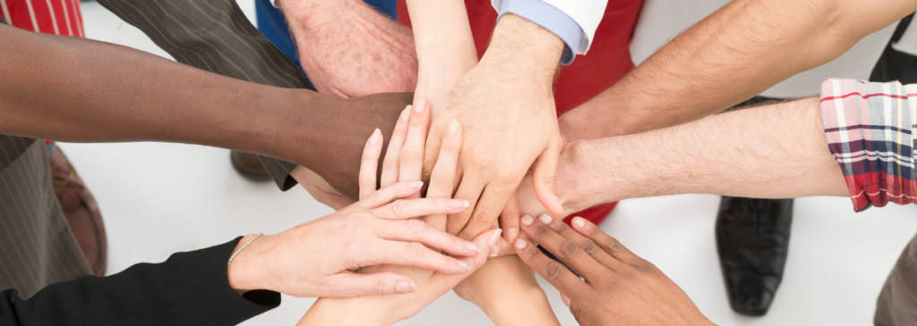 Group of people placing hands together