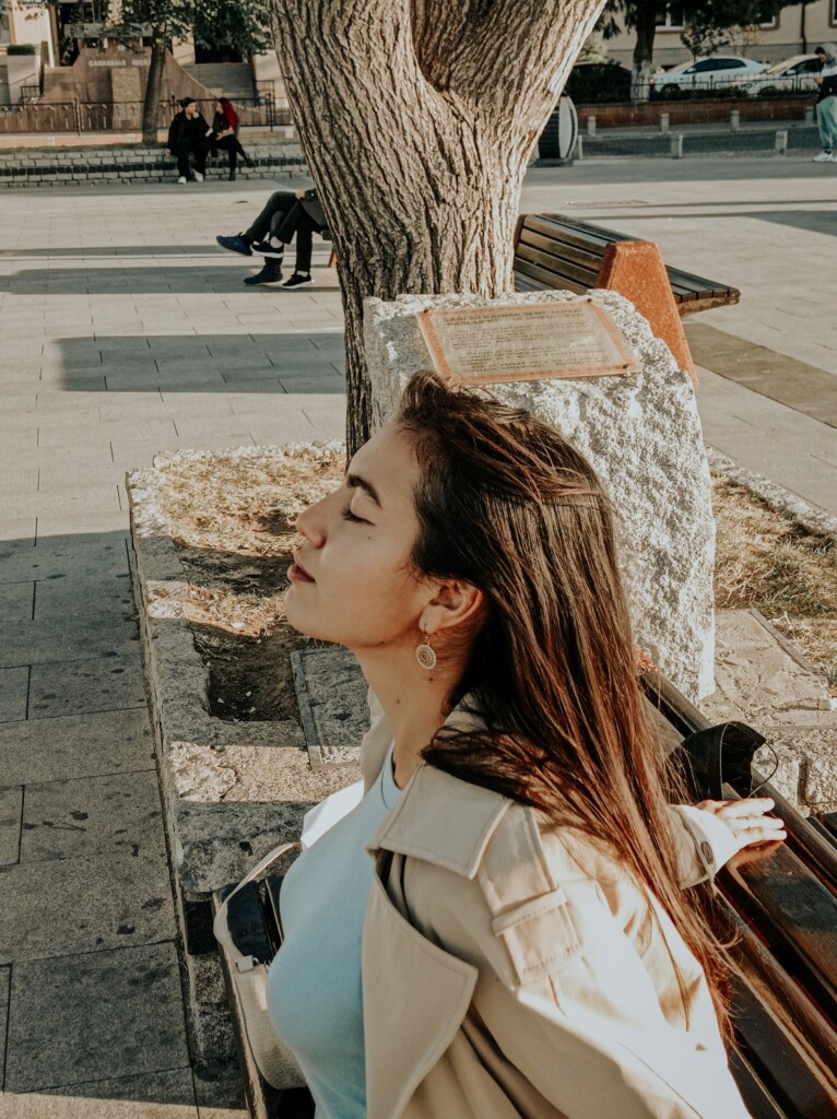 Young woman sitting on bench practicing mindfulness