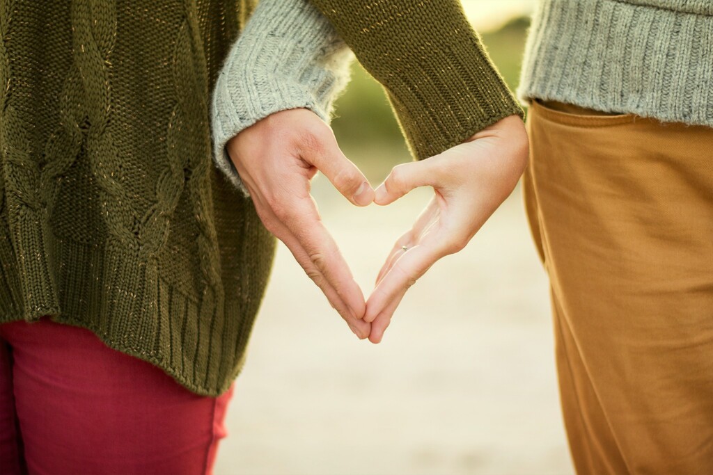 Two people creating a heart shape with their hands